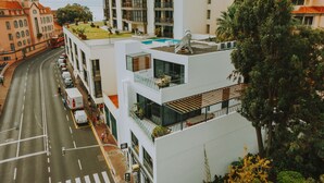 A modern building with a rooftop garden, a swimming pool, and a visible supermarket sign. - FLH Casa Branca Madeira 301 (Funchal)