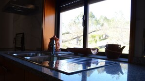 A kitchen with a large window, a sink, and a countertop.