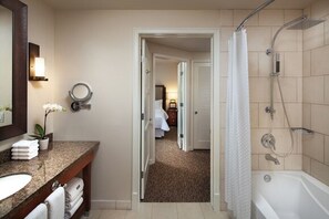 Bathroom features a sink, mirror, and potted plant, with a shower and bathtub.