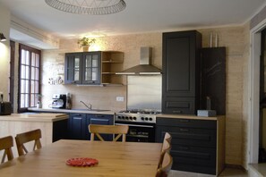 Een moderne keuken met een centraal eiland, inbouwkeukens en een kookplaat.