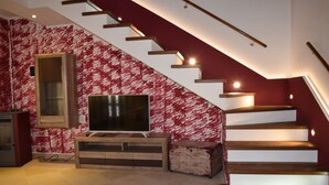 A staircase with wooden steps and a red wall with a white pattern. - Cadorna Residence in Sonia (Tarvisio)