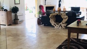 A spacious living area with high ceilings and exposed beams, a fireplace, and a view of the outdoors. - Villa with a heated pool and a lazy river, incredible views of the mountains (Tourrettes-sur-Loup)