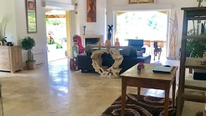 A spacious living room with a fireplace, a dining area, and a view of the outdoors. - Villa with a heated pool and a lazy river, incredible views of the mountains (Tourrettes-sur-Loup)