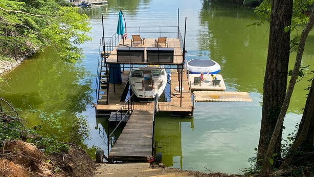 A dock with a boat and a floating platform with a trampoline. - Wildwood on the lake, views, private dock, quiet cove, dog friendly  (Gainesville)