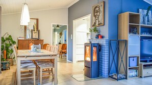 Een moderne woonkamer met een open haard, houten meubels en een boekenkast.