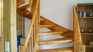 A wooden staircase with a simple design, leading to an upper floor.