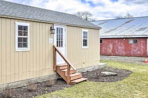A single-story building with a wooden staircase leading to a white door. - Cottage Complex · Poconos Luxury Stay (Pleasant Mount)