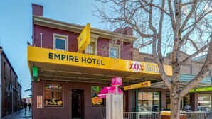 The exterior of the Empire Hotel with a prominent yellow awning and a sign for XXX Gold Bar. - Empire Hotel Goulburn (Goulburn)