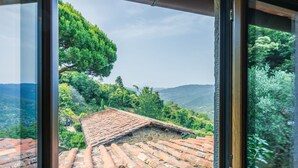 A view from a window overlooking a terraced roof and lush greenery. - Cosy apartment for 4 people with WIFI, pool, TV and patio (Pescia)