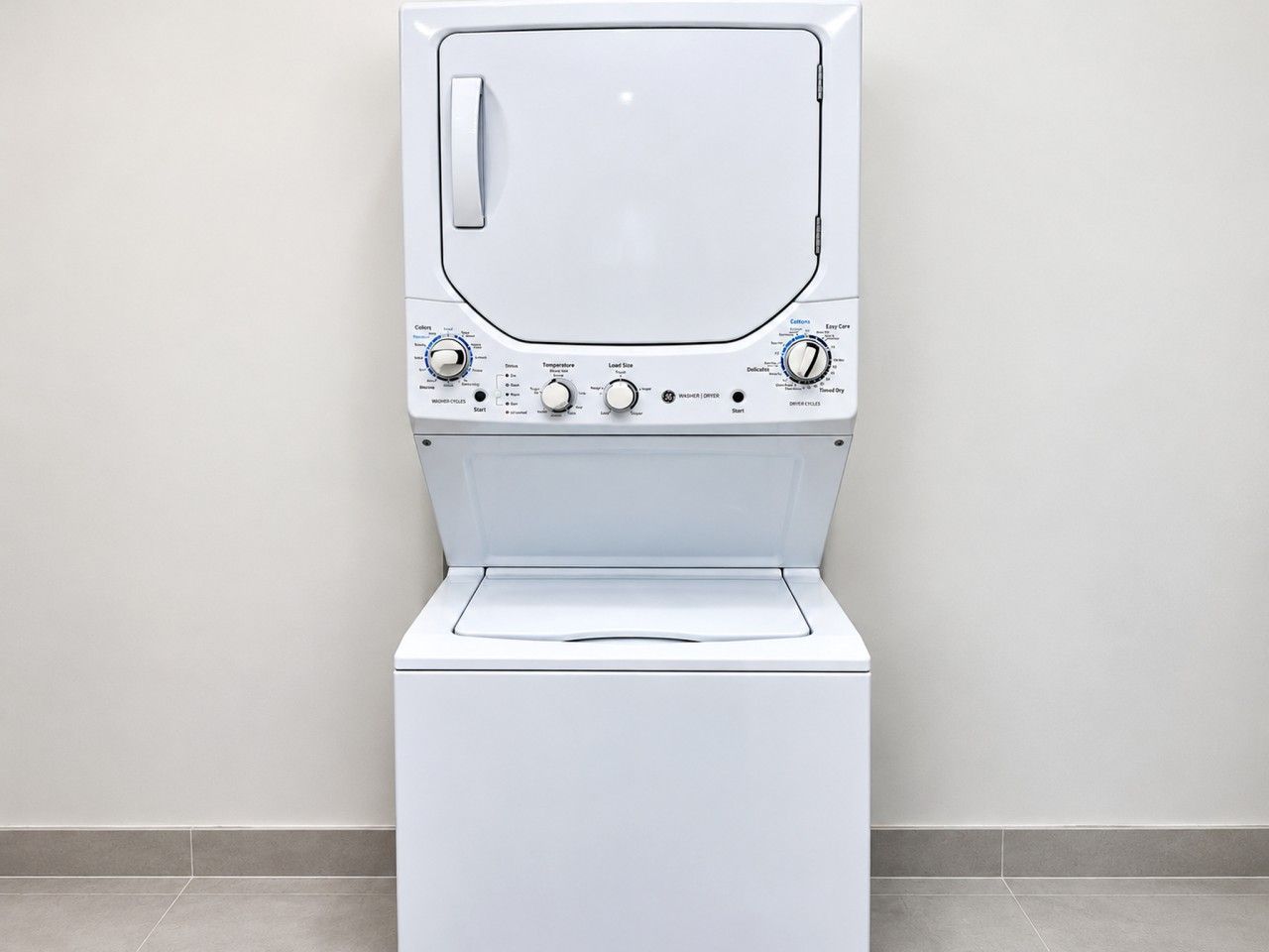 Une vue de face d’un lave-linge blanc, avec ses boutons de commande et sa porte.