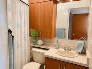 Ein Badezimmer mit Toilette, Waschbecken und Holzschränken.