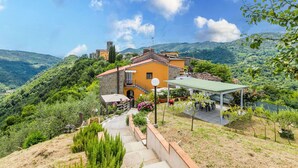 A hillside villa with a stone staircase leading to a covered patio area. - Nice apartment in villa for 6 people with pool, WIFI, TV and terrace (Pescia)