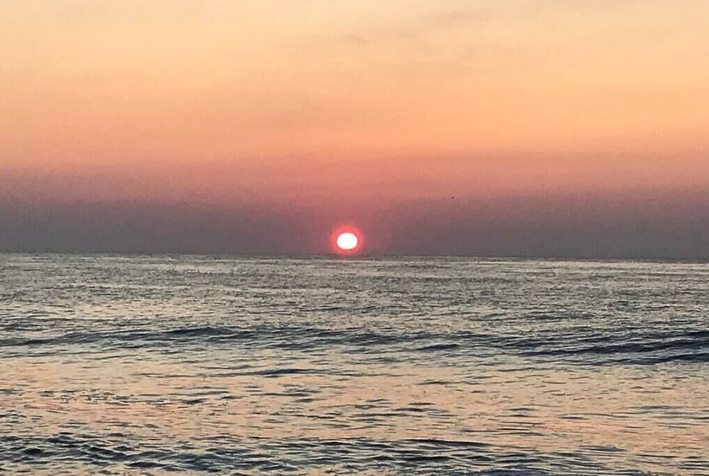 A sunset over a calm sea.