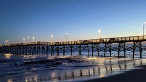 Un muelle que se adentra en el agua, con luces a lo largo de su extensión.