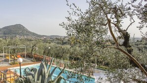 Ein Poolbereich mit Blick auf eine Berglandschaft und eine Stadt im Hintergrund.