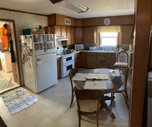 Enjoy meals in the kitchen with a refrigerator, stove, and microwave, and dine at the round table with two chairs.