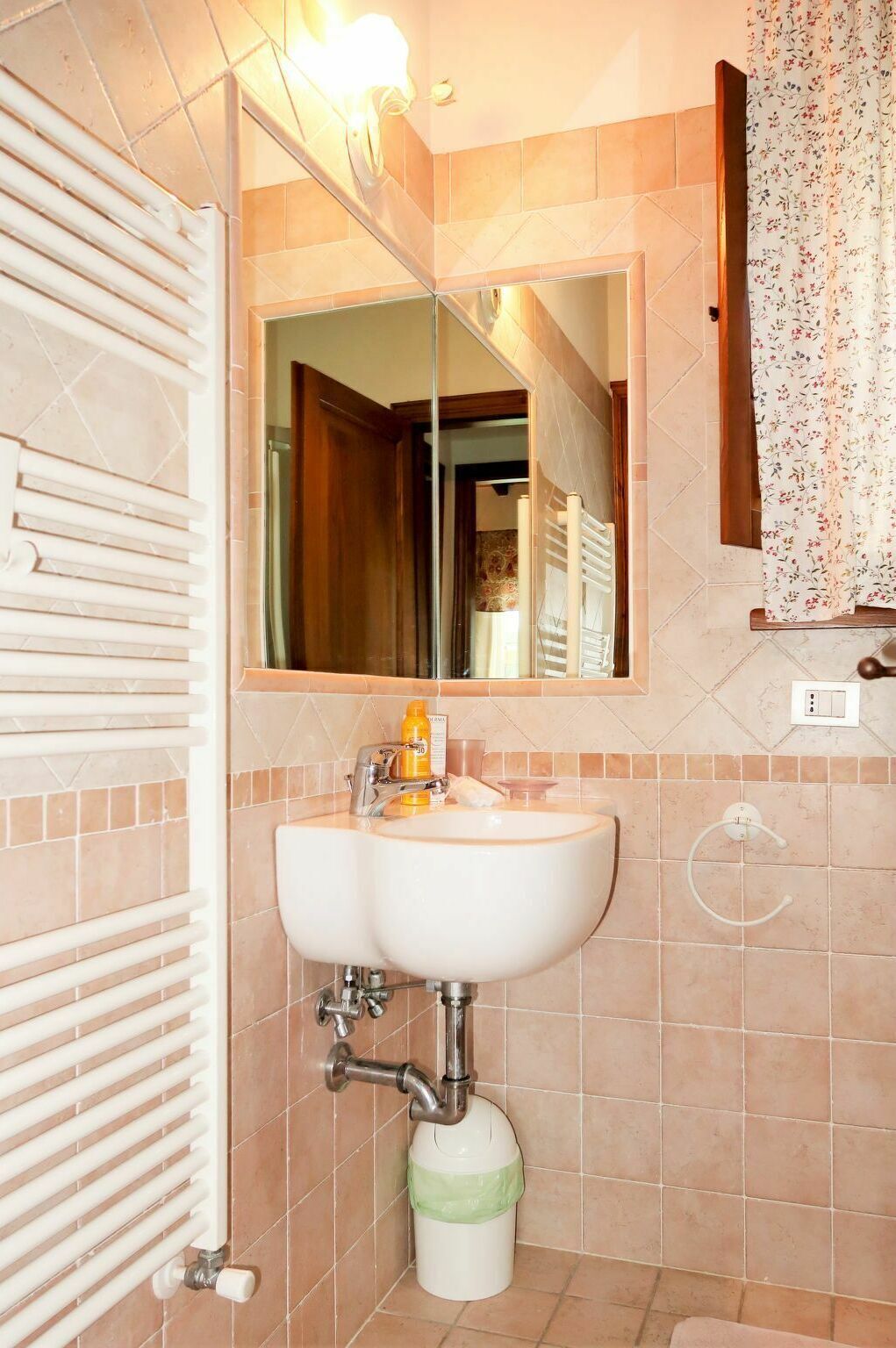 Une salle de bain avec un lavabo blanc, un miroir et un porte-serviettes.