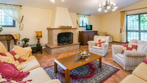 A cozy living room with a fireplace, comfortable seating, and decorative lighting. - Cosy apartment for 8 people with pool, WIFI, TV, terrace, pets allowed and panoramic view (Pergine Valdarno)