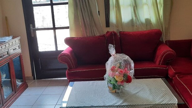 A red sofa with a glass coffee table in front. - Nzecy Appart. A studio with a velvety, air-conditioned living room. (Libreville)