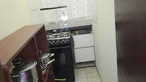 A compact kitchen with a stove, oven, and sink. - Nzecy Appart. A studio with a velvety, air-conditioned living room. (Libreville)