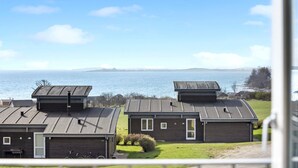 A row of houses with flat roofs, a grassy yard, and a view of the sea. - Pet friendly home in Faaborg with sauna (Faaborg)