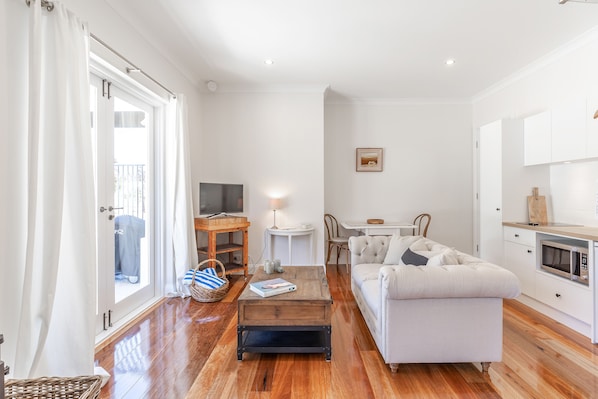 Una sala de estar moderna con sofá, mesa de centro y un comedor con mesa y sillas.