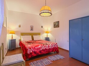 A bedroom with a bed, two bedside lamps, a hanging lamp, a wardrobe, and a small cabinet. - Lovely apartment for 4 people with WIFI, pool, terrace, pets allowed and panoramic view (Certaldo)