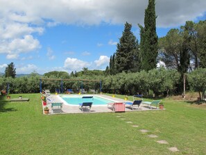 A swimming pool with lounge chairs and a pergola, surrounded by greenery and trees. - Lovely apartment for 4 people with WIFI, pool, terrace, pets allowed and panoramic view (Certaldo)