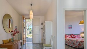 A room with a tiled floor, a bed with floral bedding, a wooden dresser, a chair, a large mirror, and a hanging light fixture. - Beautiful apartment for 6 people with pool, WIFI, TV, patio, pets allowed and panoramic view (Certaldo)