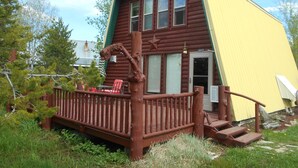 A wooden cabin with a porch, a star decoration, and a number '3412' on the door.