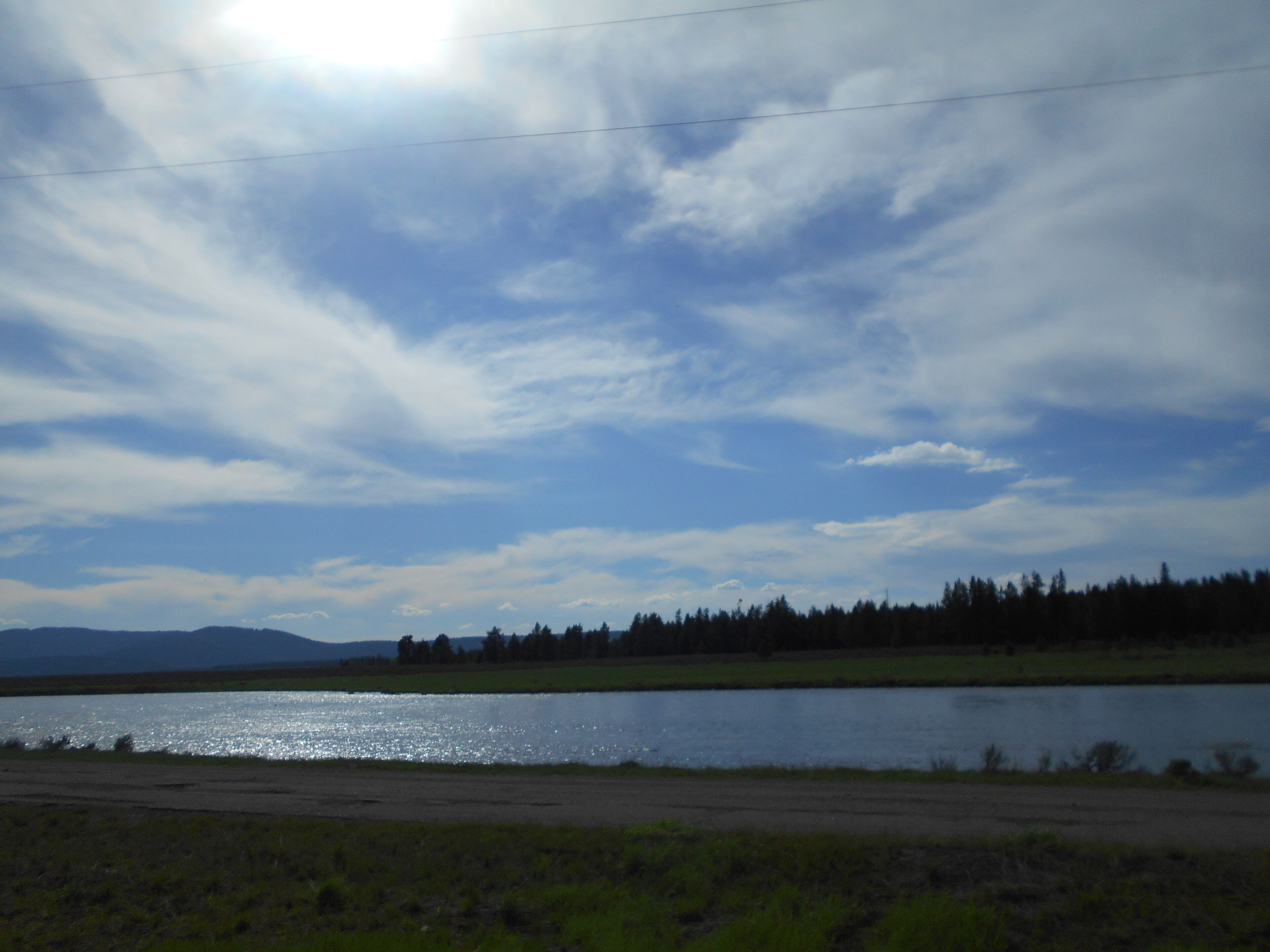 A body of water with a forested area and distant mountains.