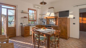 Una cocina con una mesa de comedor, sillas y un televisor.