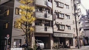 A multi-story building with balconies, a ground-level entrance, and a parked bicycle. - Nestle Tokyo Deluxe Akihabara 04 (Tokyo)