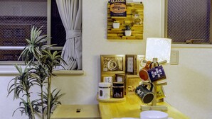 A kitchen with a wooden countertop, a potted plant, and a wall-mounted sign. - Nestle Tokyo Deluxe Akihabara 02 (Tokyo)