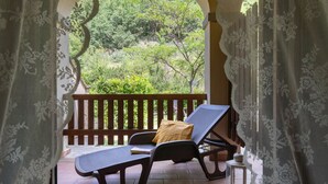 A balcony with a view of a lush green landscape, a lounge chair, and a small table. - Cosy apartment in villa for 4 people with WIFI, pool, TV, patio, pets allowed and panoramic view (Dicomano)