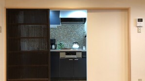 Een moderne keuken met een koffiezetapparaat, waterkoker en vaatwasser.