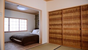 Een traditionele Japanse kamer met tatami vloerbedekking, een futon bed, een shoji scherm en een schuifdeur.