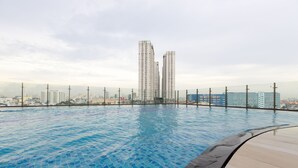 A rooftop swimming pool with a cityscape view.