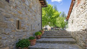 A stone staircase leading up to a building with a rustic stone wall and a wooden roof. - Lovely apartment in villa for 4 people with pool, WIFI (Loro Ciuffenna)