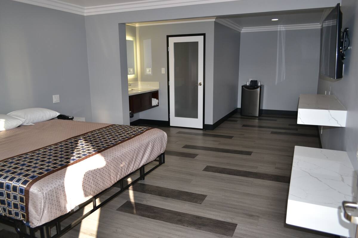 A hotel room with a bed, a bathroom, and a desk.