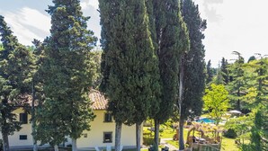 A building with a tiled roof, surrounded by a stone wall and trees. - Beautiful apartment in villa for 10 guests with private pool, WIFI, TV, terrace and pets allowed (Greve In Chianti)