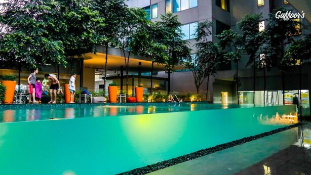 A swimming pool with a modern building in the background. - Resort Hostel In City (Kuala Lumpur)