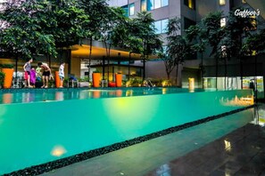 A swimming pool with a modern building in the background. - Resort Hostel In City (Kuala Lumpur)