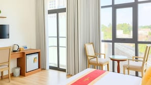 A hotel room with a bed, a desk, a chair, a small table, and a TV. - S79 Anh Duc Hotel 2 (Ho Chi Minh City)