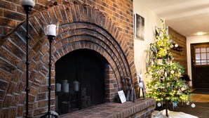 Ein Kamin aus Ziegelsteinen mit Weihnachtsbaum und Dekorationen.