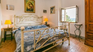 A bedroom with a bed, two bedside tables, a window, and a wooden wardrobe. - Lovely apartment in villa for 5 people with pool, WIFI, TV, patio and pets allowed (Poggibonsi)