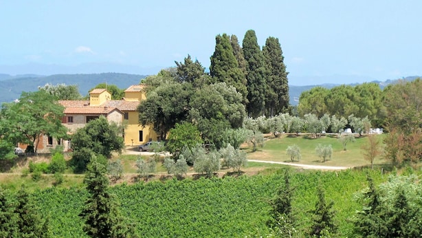 A rural landscape with a yellow building surrounded by trees and a vineyard. - Nice apartment for 4 people with WIFI, pool, TV, patio, pets allowed and panoramic view (Tavarnelle Val Di Pesa)