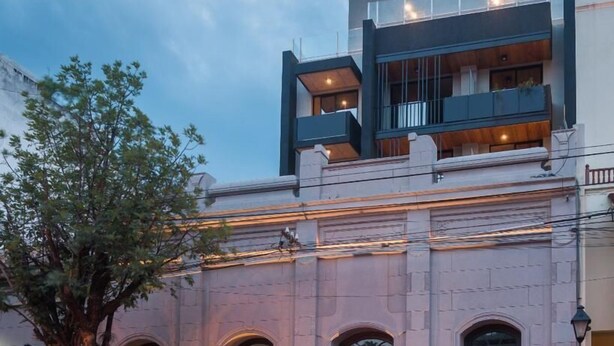 A historic building with arched windows and a red awning. - Anden by FMA Coliving (Salta)