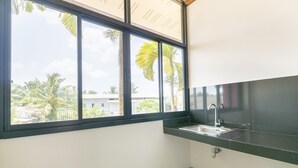 Eine Küche mit einem großen Fenster, einer Spüle und einer Arbeitsfläche.