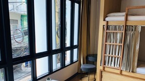 A compact room with a bunk bed, a small table, and a chair. - Daraya Hostel (Bangkok)